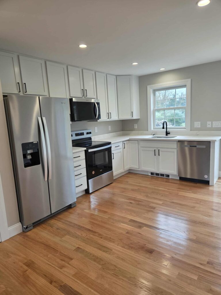 Modern kitchen with stainless steel appliances and hardwood floors.