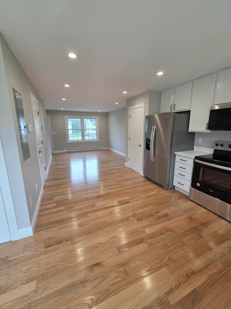 Modern kitchen with hardwood floors and stainless steel appliances.