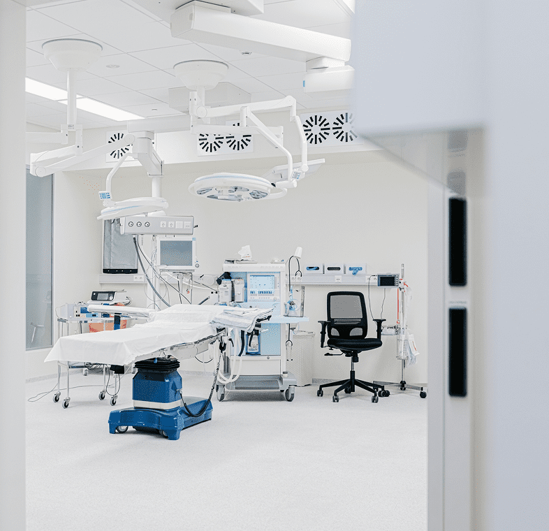 A clean, modern dental clinic room with dental chair and equipment.